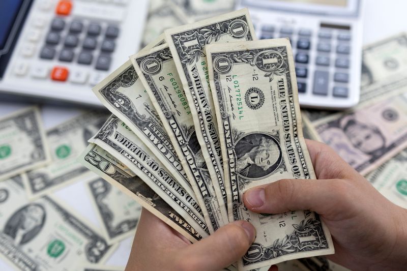 © Reuters. Woman holds U.S. dollar banknotes in this illustration taken on May 30, 2022. REUTERS/Dado Ruvic/Illustration/File Photo