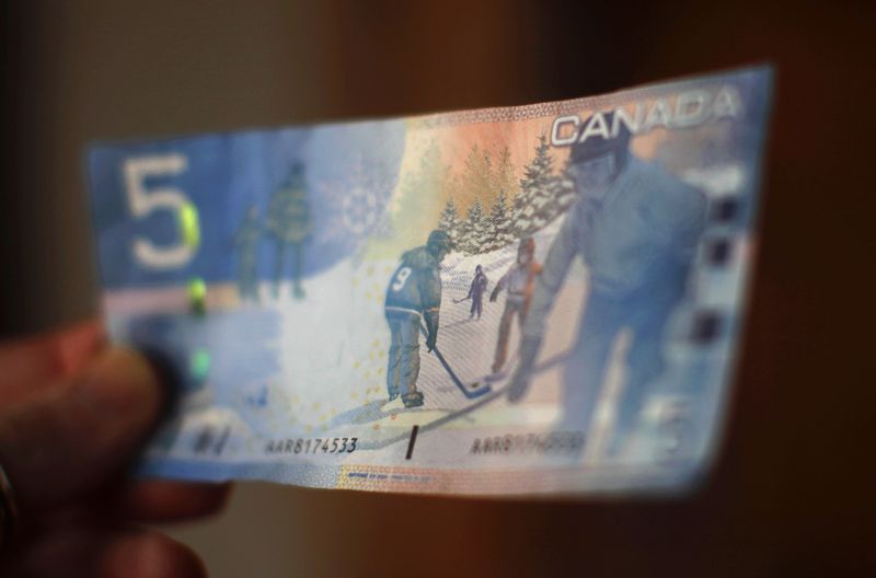 © Reuters. FILE PHOTO: A Canadian five-dollar bill is seen in this posed photograph in Montreal March 10, 2011. REUTERS/Shaun Best/File photo