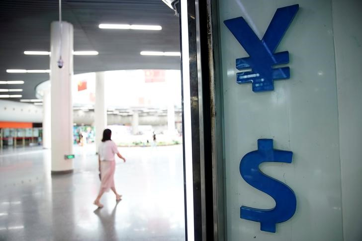 © Reuters. Signs of Chinese yuan and U.S. dollar are seen at a currency exchange store in Shanghai, China August 8, 2019. REUTERS/Aly Song/File Photo