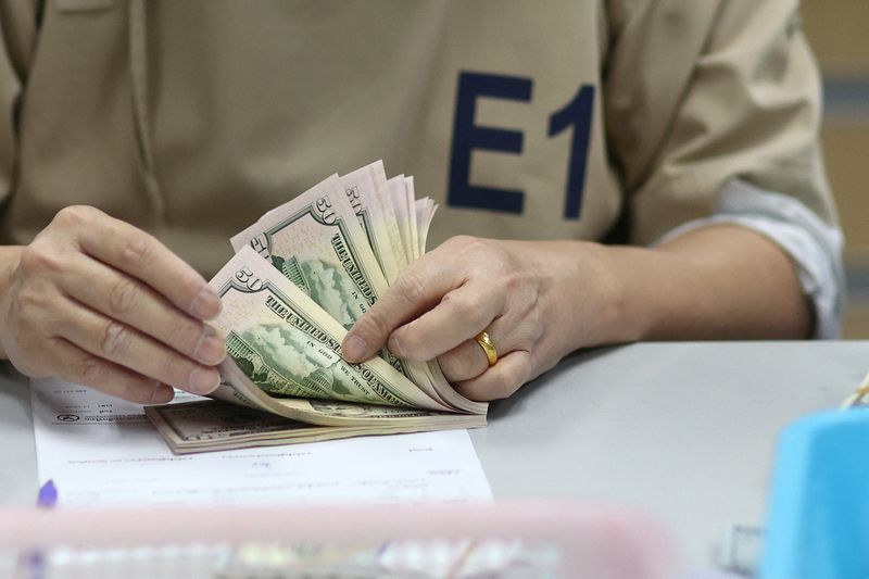 © Reuters. FILE PHOTO: A bank employee counts U.S. dollar notes at a Kasikornbank in Bangkok, Thailand, January 26, 2023. REUTERS/Athit Perawongmetha/File Photo